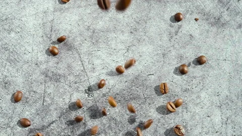 Coffee beans fall onto the concrete surface. Stock Footage 151410559