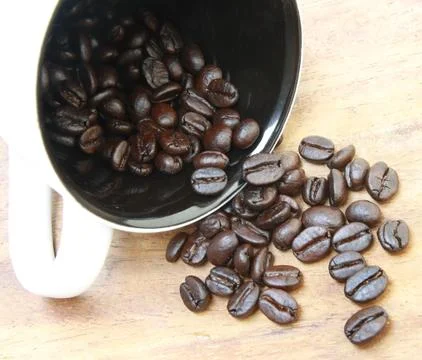 Coffee beans fall from cup Stock Photos