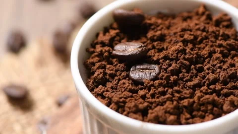 Coffee beans fall on instant coffee in a cup. Video stock 131452335