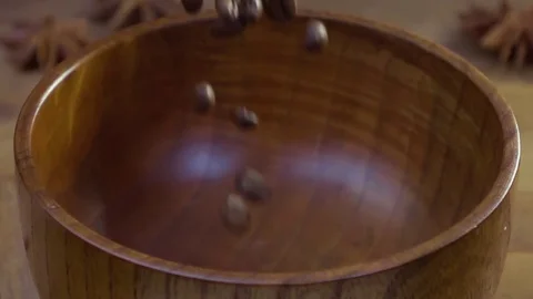 The coffee beans fall on the table in a wooden dish. The gray background. The Stock Footage 79042097