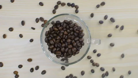 Coffee beans fall into a transparent cup. Coffee is scattered. Vídeos de archivo 94674923