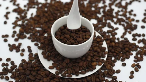Coffee beans fall in white coffee cup on a white background, the concept of Stock-Footage 135014587