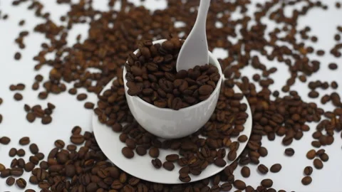 Coffee beans fall in white coffee cup on a white background, the concept of Stock Footage 135071752