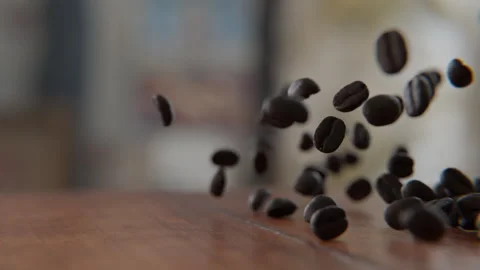 Coffee beans falling on and bouncing off of the wooden table Stock Footage 253626742