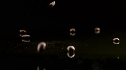 Coffee beans falling on a black mirror Stock Footage 195114771