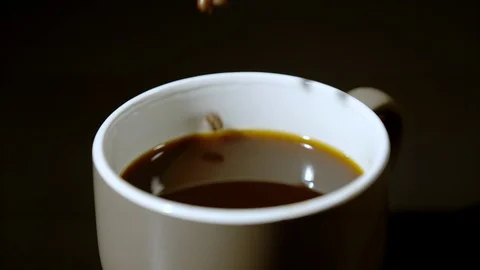 Coffee beans falling into a coffee cup, Ultra Slow Motion Video stock 86577920