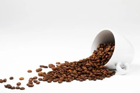Coffee beans falling from coffee cup Stock Photos