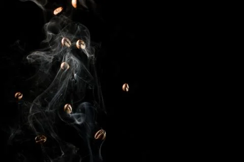 Coffee beans falling down trough smoke over black background - isolated Stock Photos