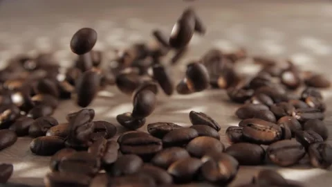 Coffee beans falling onto flat wooden surface. Stock Footage 237194360