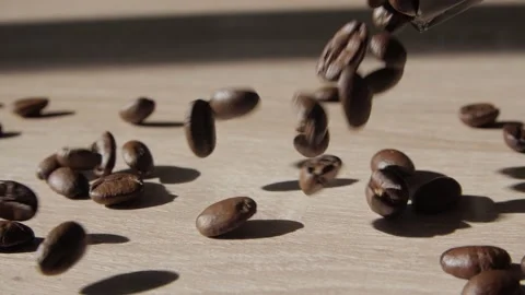 Coffee beans falling onto flat wooden surface. Stock Footage 237194368