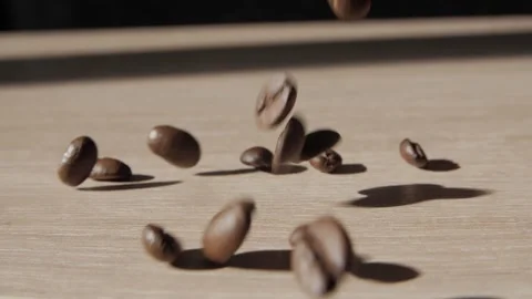 Coffee beans falling onto flat wooden surface. Stock Footage 237194387