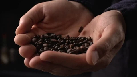 Coffee beans falling on man's hand in slow motion Video stock 114710556