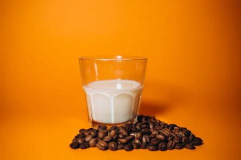 Coffee Beans Falling on Milk Splash Stock Photos