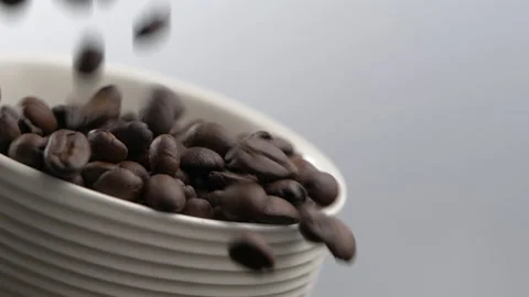 Coffee beans falling in slow motion. Coffee cup full of coffee beans Stock-Footage 132227979