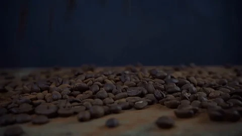 Coffee beans falling on a table on dark background, coffee slow motion footage Stock Footage 125401836