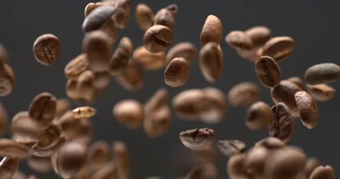 Coffee beans falling through the air in dramatic slow motion black background Stock Footage 342590891