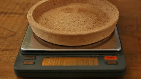 Coffee beans falling on weighs Stock Footage