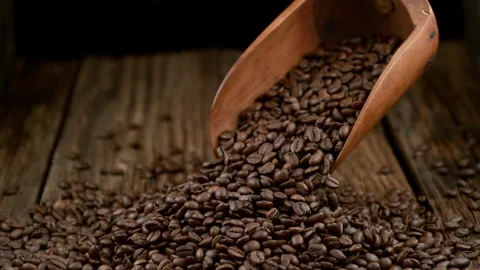 Coffee beans falling on wooden surface in slow motion.  Shot with Phantom Flex Stock Footage 162835354