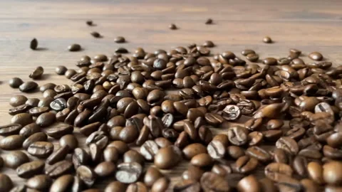 Coffee beans falling on wooden surface close-up. Video stock 273773271