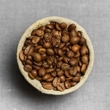 Coffee beans in flax sack on grey background Stock Photos