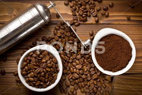 Coffee beans with ground coffee and grinder Stock Photos