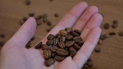 Coffee beans in hand Stockbeeldmateriaal 166534188