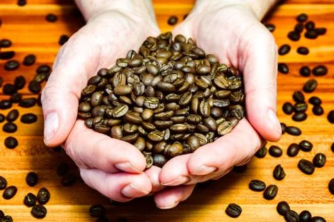 Coffee beans in hands Stock Photos
