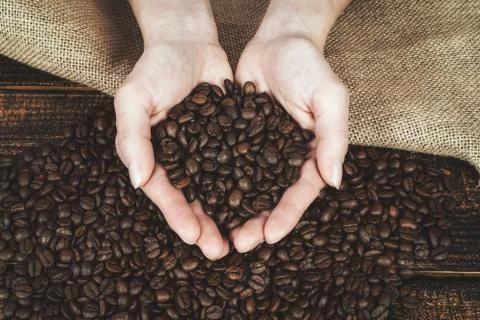 Coffee beans in hands Stock Photos