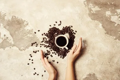 Coffee beans in heart shape on background fabrics of jute Stock Photos