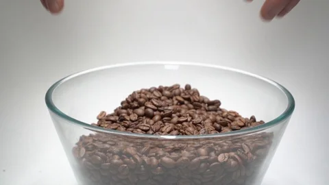 Coffee beans in a large transparent cup. Men's hands go down through the grains Video stock 123093378