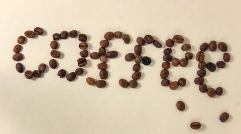 Coffee beans, on a light background, create the word COFFEE. Foto stock