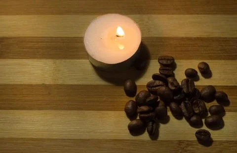 Coffee beans, a lighted candle Stock Photos