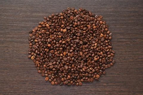 Coffee beans, loose in the circle shape on dark wooden table Stock Photos