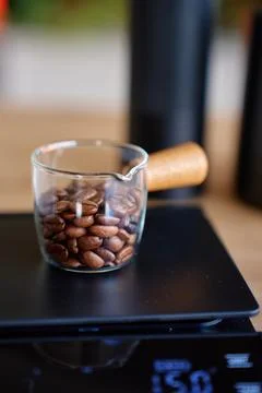 Coffee beans measured on digital scale before brewing Stock Photos