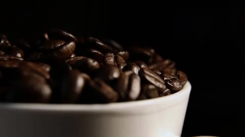 Coffee beans in a mug rotate on a black background. coffee beans. Stock Footage 169766115