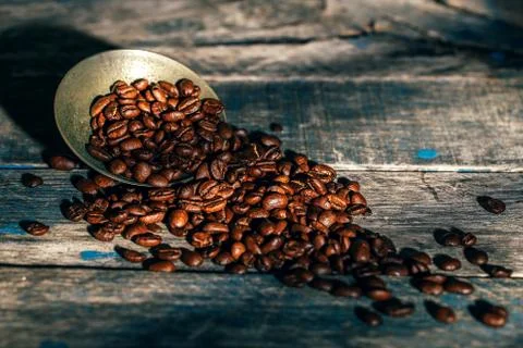Coffee beans in old small silver with the rustic blue wooden background with Stock Photos