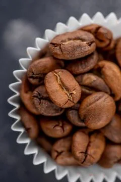 Coffee beans in the package from candy on a dark background. Close-up. Stock Photos