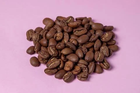 Coffee beans on a pink background. Stock Photos