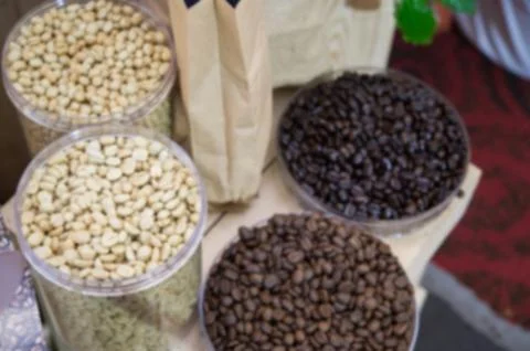 Coffee beans in plastic tray  on brown wooden background ,blurry background 스톡 사진