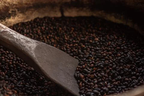Coffee beans, roasted coffee beans are mixed with a spatula. Stock Photos