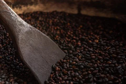 Coffee beans, roasted coffee beans are mixed with a spatula. Foto stock