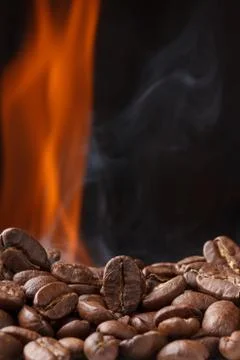 Coffee beans roasting with fire and smoke Foto stock