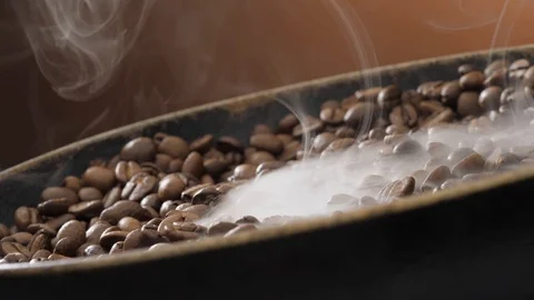 Coffee beans rotate while roasting. Smoke comes from coffee beans. Stock Footage 120203233