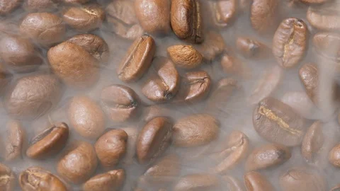 Coffee beans rotate while roasting. Smoke comes from coffee beans. Stock Footage 120203508
