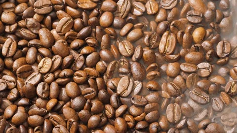 Coffee beans rotate while roasting. Smoke comes from coffee beans. Stock Footage 120203703