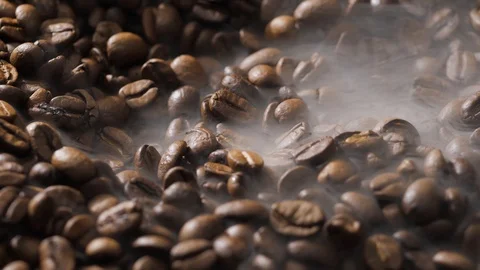 Coffee beans rotate while roasting. Smoke comes from coffee beans. Stock Footage 120982740