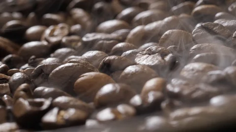 Coffee beans rotate while roasting. Smoke comes from coffee beans. Stock Footage 120983614