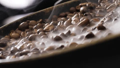 Coffee beans rotate while roasting. Smoke comes from coffee beans. Stock Footage 120984570