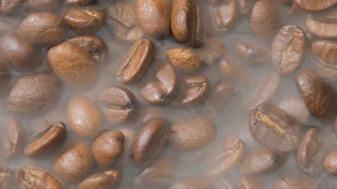 Coffee beans rotate while roasting. Smoke comes from coffee beans. Stock Footage 120984770