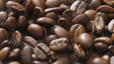 Coffee beans rotate while roasting. Smoke comes from coffee beans. Stock Footage 121229913